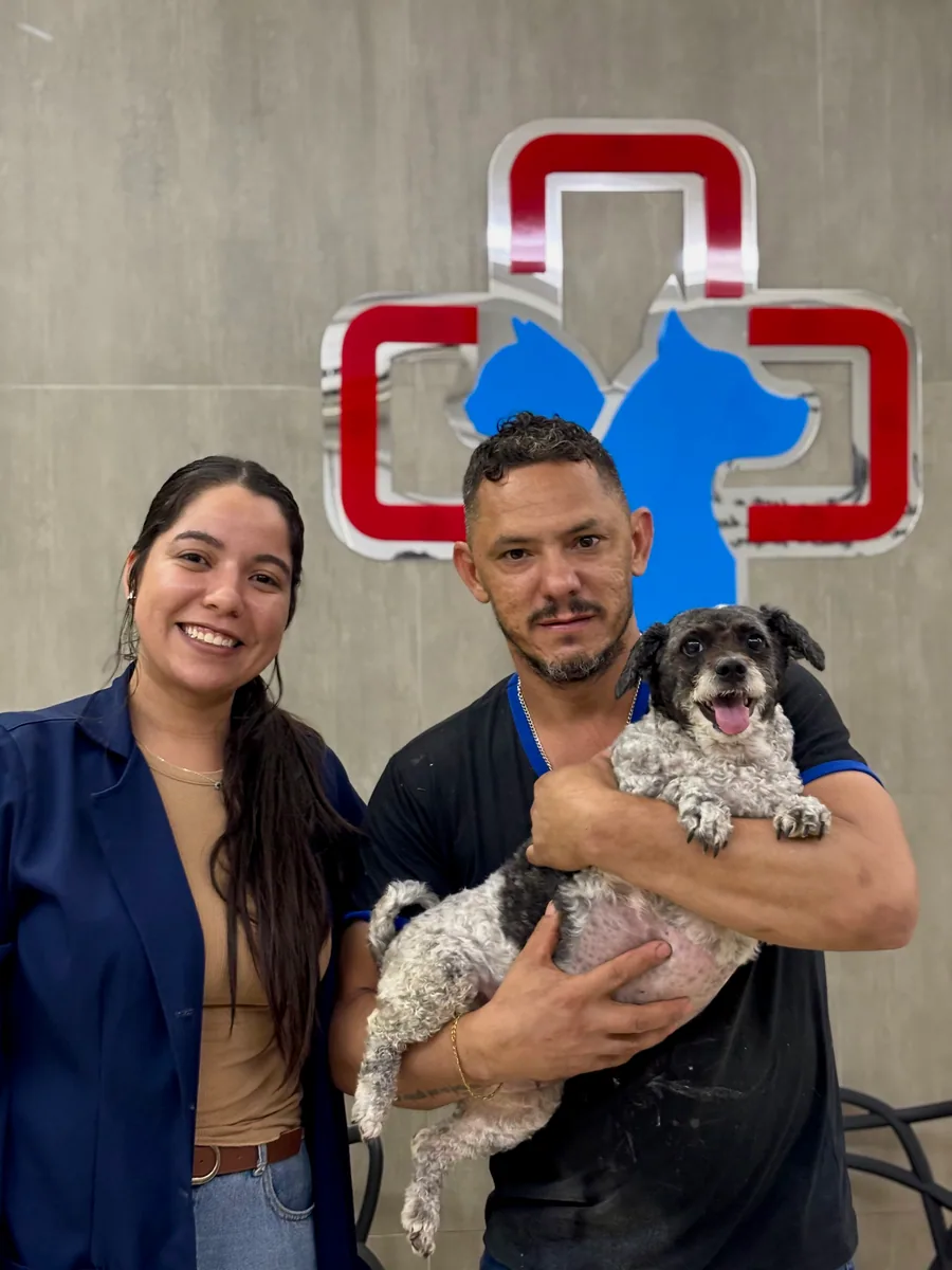 Cliente com seu cachorro e uma profissional do PetCampos
